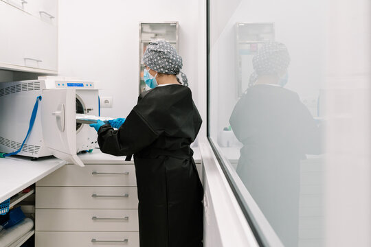 Doctor Placing Medical Tools In Steam Sterilization