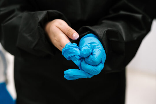 Doctor Taking Off Latex Gloves In Hospital