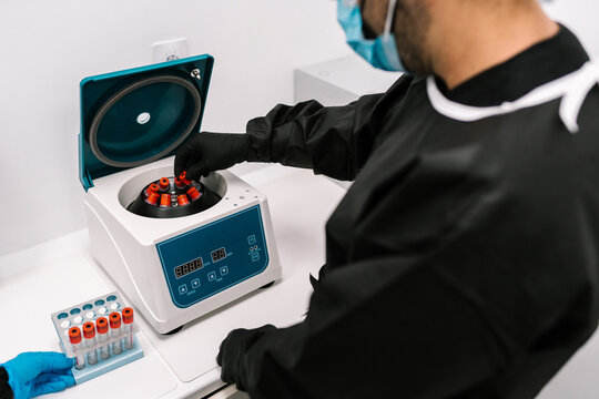 Doctor putting blood samples into centrifuge