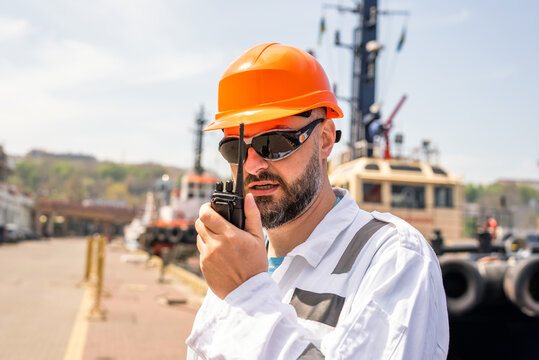 Seaman talking with walkie-talkie radio in port