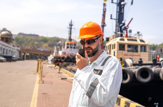 Seaman talking with walkie-talkie radio in port