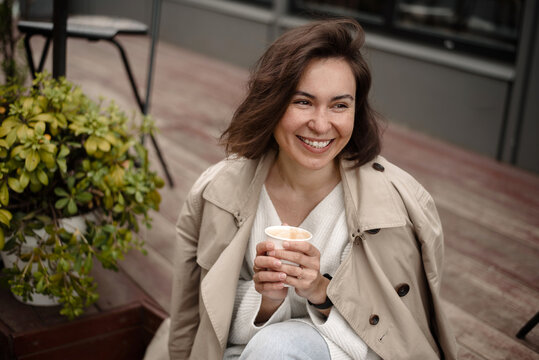 Cheerful woman having cofee outdoors