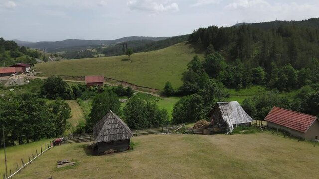 Kremna Village, Tara Mountain, Serbia. Aerial View of Small Farm, Vintage Wooden Barns and Green Pastures on Summer Day, Drone Shot