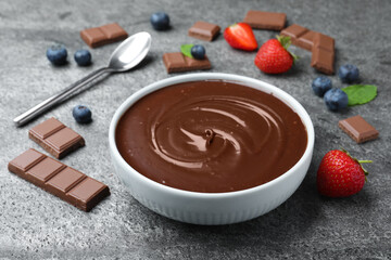 Delicious chocolate cream with berries and mint on grey table