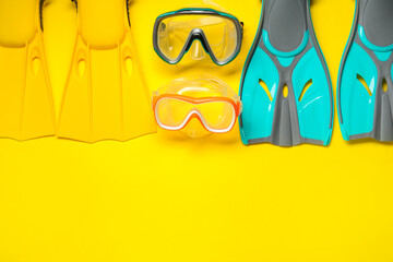 Different flippers and masks on yellow background, flat lay. Space for text © New Africa