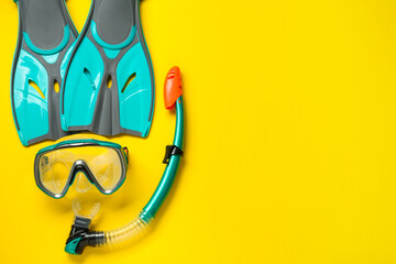 Pair of turquoise flippers and mask on yellow background, flat lay. Space for text © New Africa