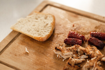 Wooden board with bread, chicken and sausages for a picada (a snack)