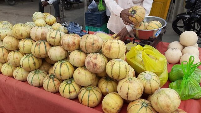 Man Selling Muskmelon Fruit in a wheelbarrow thela gaadi at Roadside of India