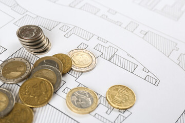 Coins on cadastral map of territory with buildings, closeup