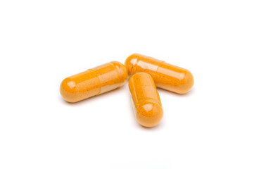 Closeup turmeric herbal powder capsules isolated on white background.