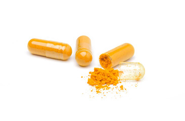 Closeup turmeric herbal powder capsules isolated on white background.