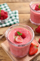 Delicious berry mousse with mint on wooden table