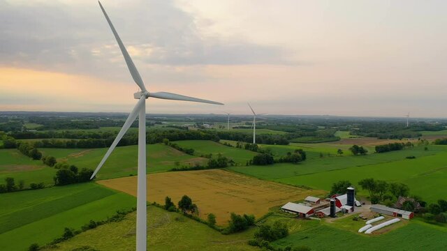  Aerial view of Wind turbines, windmill, farm, agricultural fields at sunrise sunset. Rural landscape. Renewable green energy concept, dawn dusk sky 
