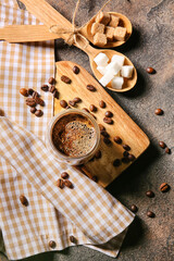 Cup of hot turkish coffee, spoons with sugar and beans on grunge background