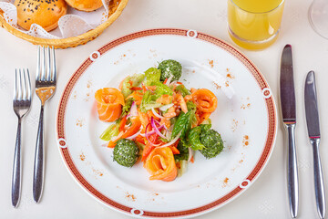 Salad with herbs, salmon and cheese balls.