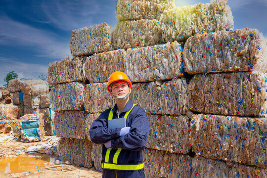 Engineer and recycle. Engineers standing in recycling center. Male foreman wearing protective equipments and holding tablet.