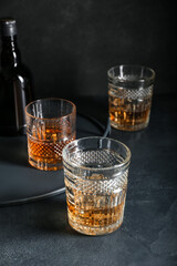Glasses of cold whiskey on dark background