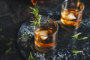 Glasses of cold whiskey on dark background