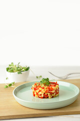 Plate with tasty tartare salad on light background
