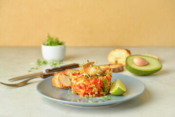 Plate with tasty tartare salad on table