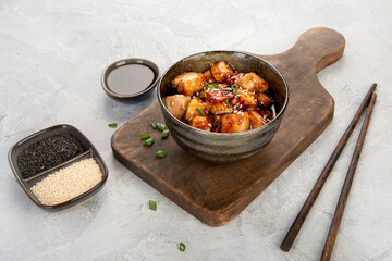 Traditional homemade fried tofu with sesame on light gray background.