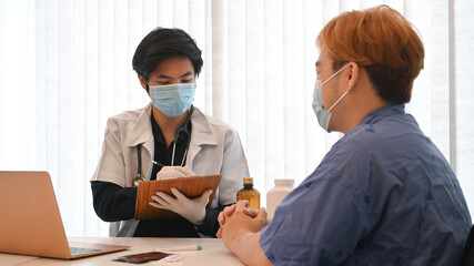 Doctor giving advice to young man patient at hospital.