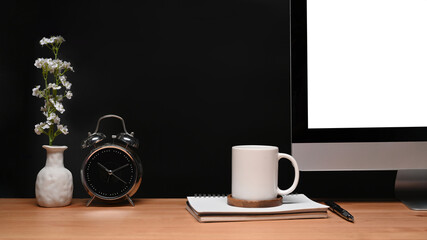 Obraz na płótnie Canvas Computer with white screen, clock and coffee cup at modern workspace.