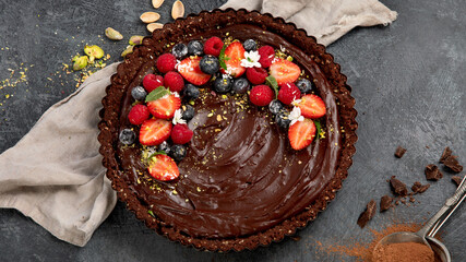 Delicious chocolate tart on gray background. Homemade desserts concept.