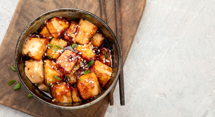 Traditional homemade fried tofu with sesame on light gray background.