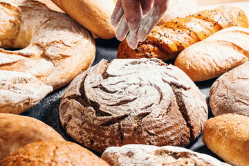 Baking close-up. Appetizing buns sprinkled with flour on a black wooden table. Bakery products.