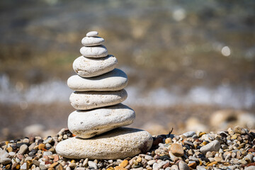 Stack of pebbles balancing on a ocean background. Sea waves are behind.