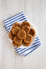Homemade Peanut Butter Cookies on a plate on a white wooden table, top view. Flat lay, overhead, from above.