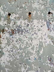 background of a very old metal rusty wall of a garage or fence with round holes, painted with paint that has begun to flake off, corrode and mold