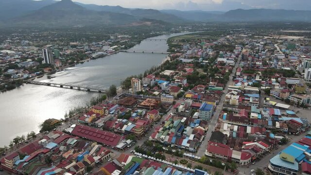 Aerial drone footage above Kampot city, houses and mountains of Bokor in Background, Cambodia