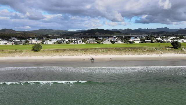 Magnificent View Of Matarangi Beach Settlement On The Coromandel Peninsula Of New Zealand. Vehicle Driving On The Sand In Summer. aerial