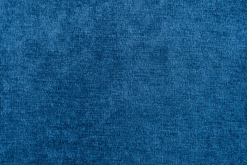 Blue texture of fabric from a textile material for an abstract background for an empty surface and for wall-paper.