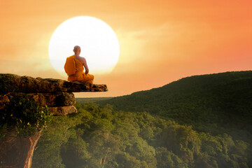 Buddhist monk in meditation at beautiful sunset or sunrise background on high mountain - obrazy, fototapety, plakaty