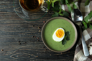 Concept of healthy food with nettle soup on wooden table