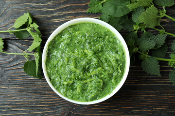 Concept of healthy food with nettle soup on wooden table