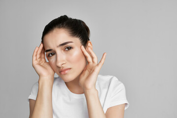 Fototapeta premium woman with headache dissatisfaction health problems medicine light background