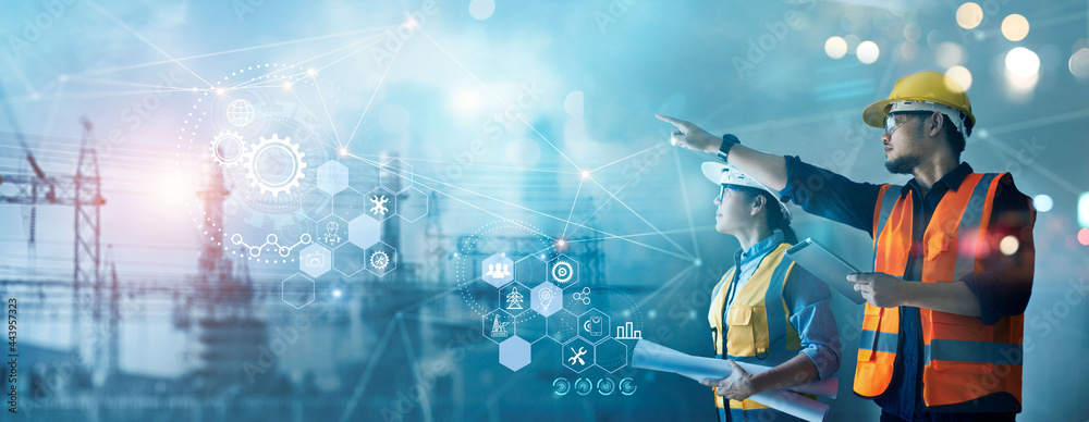 Aufkleber Male and female industrial engineers using tablet computer and blueprints checking and analysis data of power plant station project on network background.