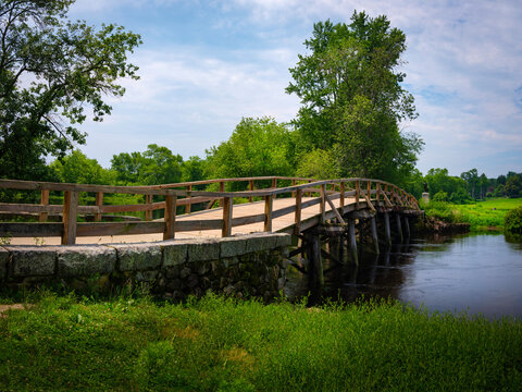 Old North Bridge at Minuteman National Historical Park in Concord, Massachusetts. Tranquil Nature Landscape with Landmark Bridge and Clean River. Peaceful American New England Image.