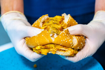 Fast food delicious sandwich. American tasty hamburger holding in hands.