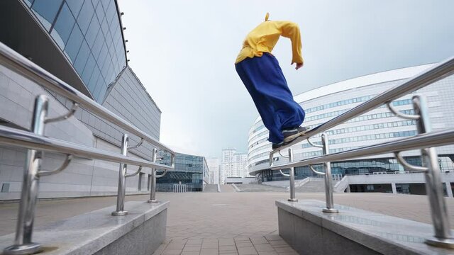 Free running, young man runs over obstacles in the city on training area near modern buildings, 4k slow motion.