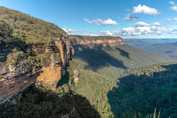Fototapeta premium Blue skies and a few clouds over some Blue Mountain cliffs and canyons.