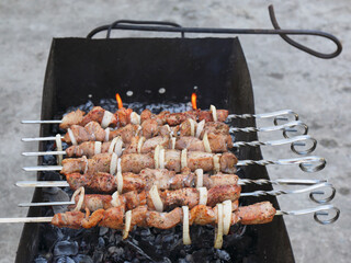 Kebabs preparing on a barbecue grill, shashlik preparing on a mangal, marinated meat preparing on a...