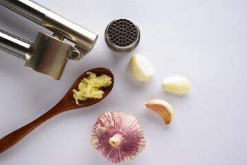 Garlic, garlic cloves, garlic press on a white background, flatlay