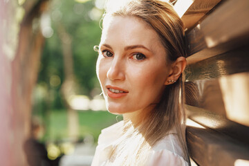 Attractive young stylish woman standing against wooden wall