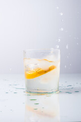 Orange fell in a glass with water isolated on white