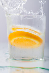 Orange fell in a glass with water isolated on white